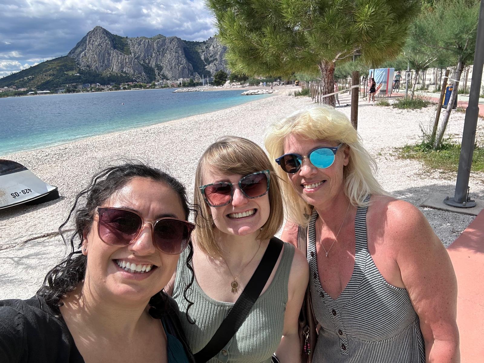Three women on the beach in Omiš with the Cetina gorge behind