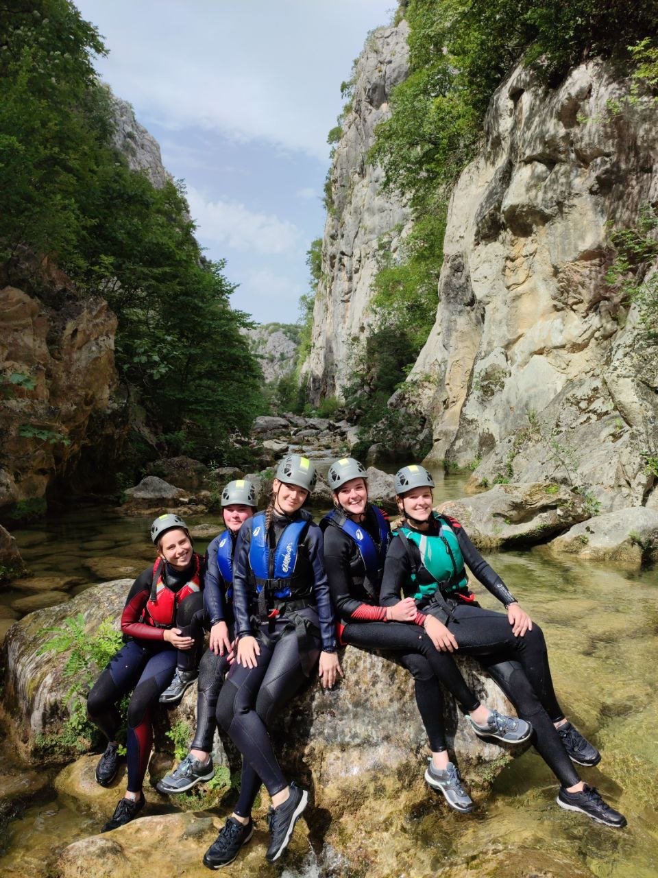 Women in wetsuits resting on a rock inside the Cetina canyon, Dalmatia