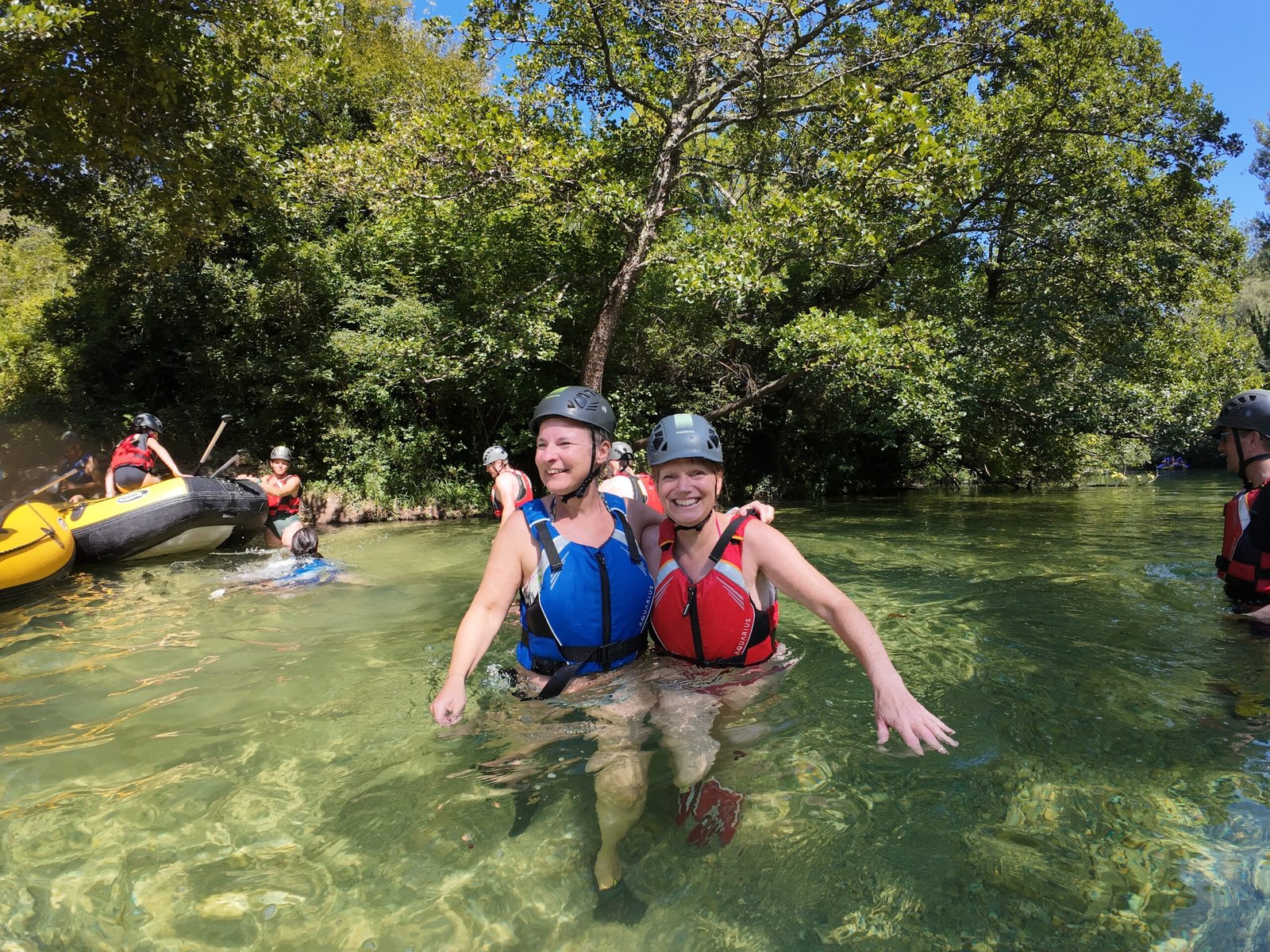 Women standing in the clear shallows of the Cetina during a rafting stop