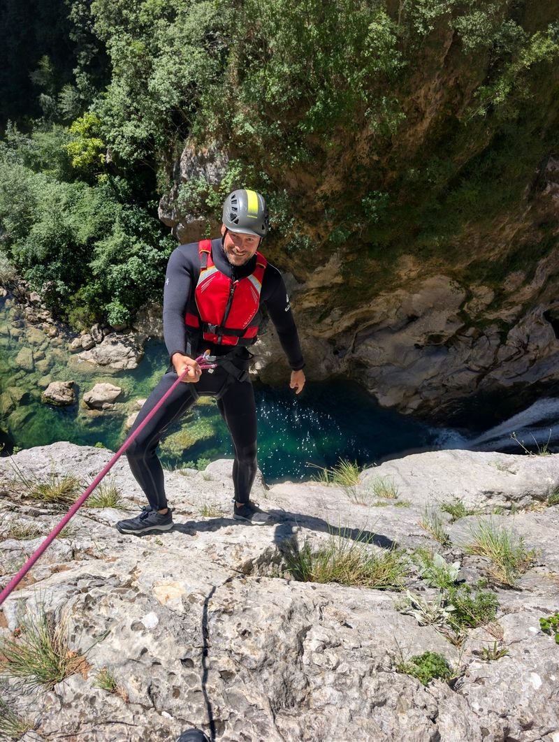 Abseiling above a waterfall pool in the Cetina canyon
